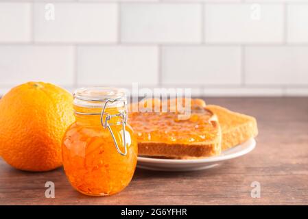 A Jar of Homemade Orange Marmalade on a Rustic Wooden Table Stock Photo