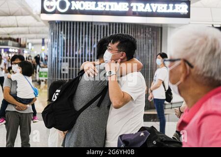 Hong Kong, China. 9th July, 2021. People hug each other at the Hong Kong International Airport. Hundreds of thousands of Hong Kong people are choosing to leave their home city for good because of the national security law and political instability. Credit: Keith Tsuji/ZUMA Wire/Alamy Live News Stock Photo