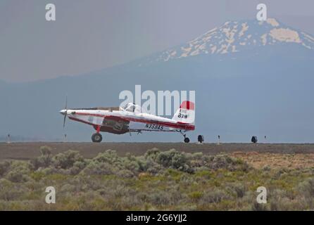 An Air Tractor carrying the fire boss, and a Coulson Flying Tanker 737 loaded with fire retardent, take off in 114 degree heat from the Redmond, Orego Stock Photo