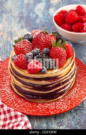 Stack of Berry Pancakes with Compote Spread on a Distressed Blue Wood Table Stock Photo