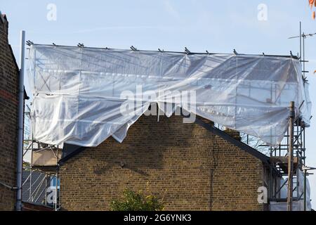 Scaffolding & covering protection on newly completed dormer / dormers / dormas / dorm on the roof on end of terrace Victorian terraced house. UK (124) Stock Photo