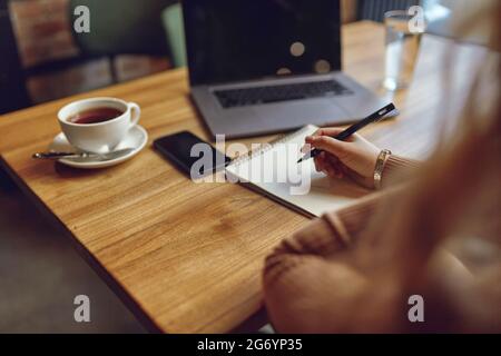 Woman using laptop and smartphone for remote work Stock Photo
