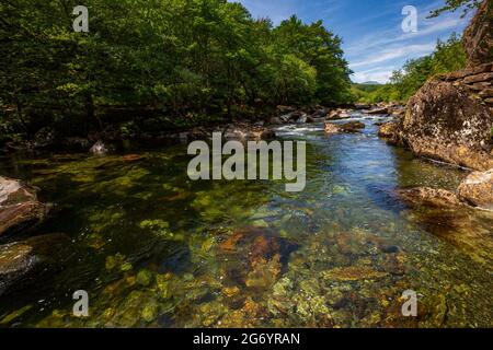 The clear waters of the Glaslyn River flowing through the Aberglaslyn Pass in the Snowdonia National Park, North Wales Stock Photo