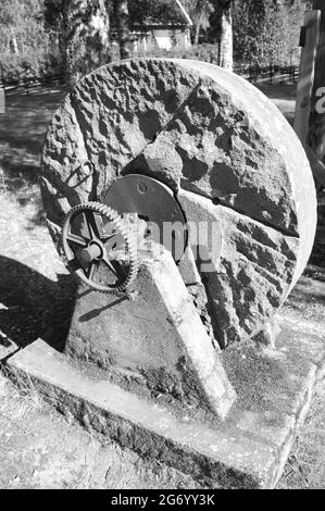 Vertical grayscale shot of a grindstone outdoors under sunlight Stock Photo