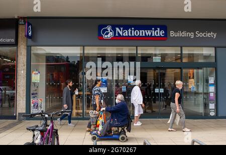 Uxbridge, London Borough of Hillingdon, UK. 9th July, 2021. People wear face masks as they walk past the Nationwide Building Society. It is expected that Boris Johnson will announce that face masks will no longer be mandatory when he lifts the Covid-19 lockdown on 19th July 2021, however, many people are reported to be feeling uncomfortable about this and that is too soon given the huge spike in postive Covid-19 cases. Credit: Maureen McLean/Alamy Live News Stock Photo