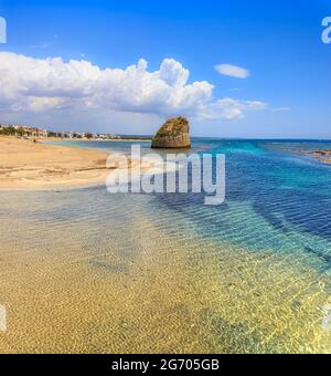Salento coast: Torre Pali Beach in Apulia, Italia. The ruined watchtower of Torre Pali appears in the blue water, a few metres away from the beach. Stock Photo