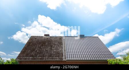 A half cleaned house roof shows the before and after effect of a roof ...