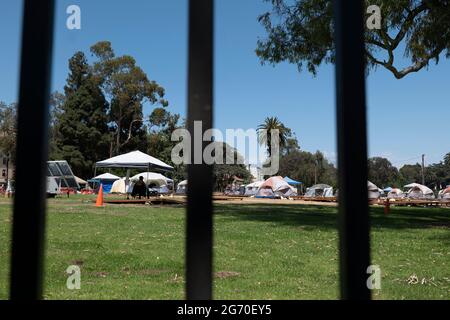 Los Angeles, CA USA - Julyl 3, 2021: Tents of homeless veterans living on the Veterans Administration grounds beyond the perimeter fence Stock Photo