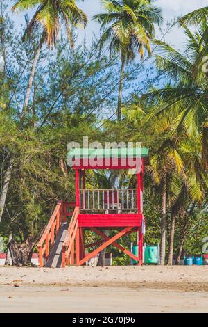 Red Life guard hut and palm trees on tropical beach. Luquillo Beach, Puerto Rico Stock Photo