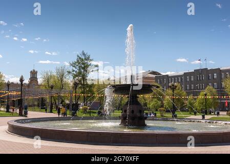 Russia, Irkutsk - May 27, 2021: fountain and hotel Angara in Tikhvinsky or Kirov Square in sunny summer day Stock Photo