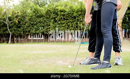 couple man with woman training golf player course golf on lawn in garden Stock Photo