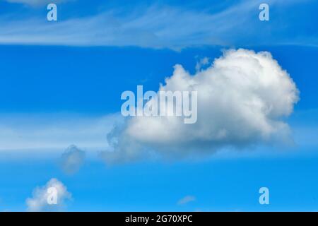 A fluffy white cloud floating in a blue sky in Alberta Canada Stock Photo