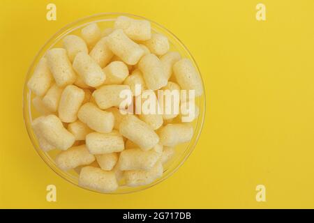 yellow sweet corn sticks in bowl isolated on yellow background, top view, empty space for text Stock Photo