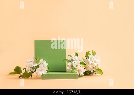 Modern abstract podium green paper geometric shapes white flowers pastel pink background. Copy space horizontal banner  Stock Photo