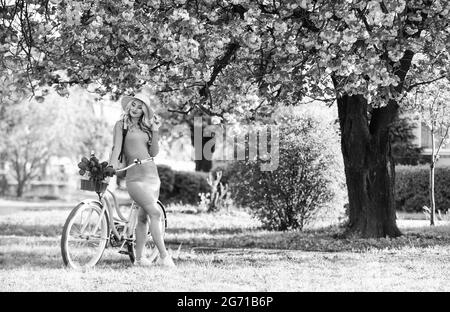 Summer day. spring blooming tree of japanese sakura. cherry beauty. flower shop. girl flower seller with retro bike. vintage bicycle for pleasant walk Stock Photo