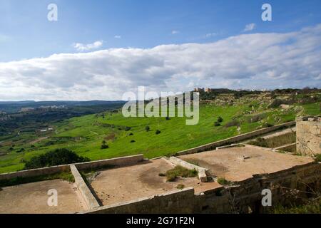 MARSAXLOKK, MALTA - 01 JAN, 2020: Panoramic view into a green valley on the island of Malta with ruin in the foreground and green terraces Stock Photo