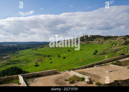 MARSAXLOKK, MALTA - 01 JAN, 2020: Panoramic view into a green valley on the island of Malta with ruin in the foreground and green terraces Stock Photo