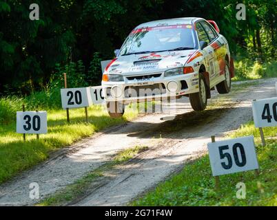 Steve Chamberlain takes off over Forest Rally Stage jump in his Mitsubishi Evo IV with all four wheels off the ground. Goodwood Festival of Speed 2021 Stock Photo