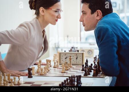 Concept of confrontation, businesspeople playing chess looking at each other with aggression Stock Photo