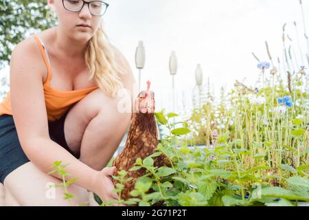 A girl and her chicken in the garden Stock Photo