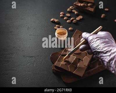 Homemade natural chocolate with edible gold on a black background. Exclusive handmade chocolate. Exclusive premium handmade chocolate. Selective focus Stock Photo
