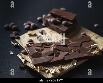 Homemade natural chocolate with edible gold on a black background. Exclusive handmade chocolate. Exclusive premium handmade chocolate. Selective focus Stock Photo