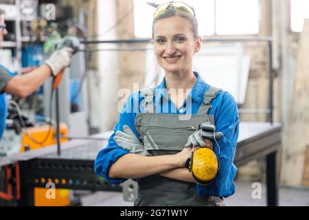 Workers in a metal workshop, man and woman Stock Photo