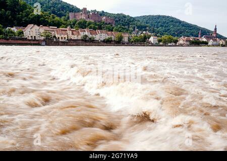 Heidelberg, Germany. 10th July, 2021. River water flows through the Neckar at the weir walkway of the hydroelectric power plant. Parts of the Alstadt and Heidelberg Castle can be seen in the background. The water level is expected to rise above the navigation limit on Saturday. Credit: Uwe Anspach/dpa/Alamy Live News Stock Photo