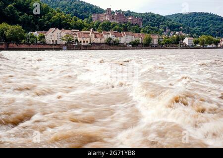 Heidelberg, Germany. 10th July, 2021. River water flows through the Neckar at the weir walkway of the hydroelectric power plant. Parts of the Alstadt and Heidelberg Castle can be seen in the background. The water level is expected to rise above the navigation limit on Saturday. Credit: Uwe Anspach/dpa/Alamy Live News Stock Photo