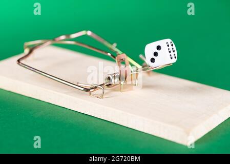 Dice and mousetrap, game trap, on a green background, get into gambling addiction. Stock Photo