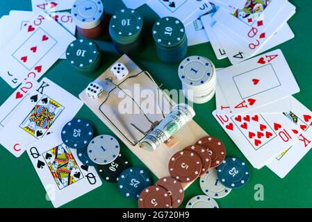 banknote and mousetrap, game trap, against the background of casino chips and dice. Stock Photo