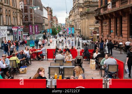 Glasgow, Scotland, UK. 10 July  2021.  Members of the public shopping and dining in outdoor cafes on Buchanan Street on a warm Saturday afternoon in Glasgow City centre.  The good weather brought many people into the city centre to take advantage of many cafes and bars that have set up outdoor seating areas  on the pavements on the city streets. Iain Masterton/Alamy Live news. Stock Photo