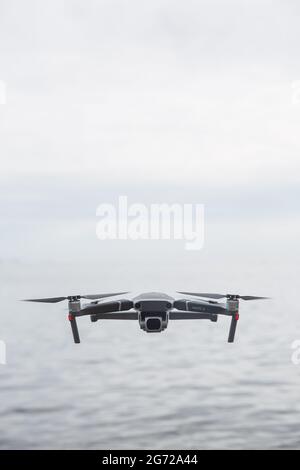 CORNWALL, UK - JUNE 29, 2021.  A DJI Mavic Pro 2 unmanned drone flying above water and facing the camera with copy space Stock Photo