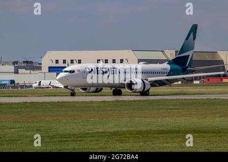 Montreal, Quebec, Canada - 06 27 2021: Westjet Boeing 737-8 MAX landing in Montreal. Registration C-GZSG. Stock Photo