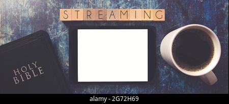 Streaming Written in Block Letters on a Wooden Table with a Bible and Tablet Stock Photo