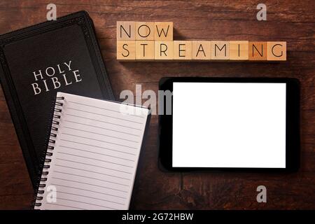 Now Streaming in Block Letters on a Wooden Table with a Bible Stock Photo