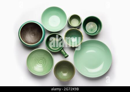 Collection of empty colorful ceramic bowls. Group of utensils captured from above, top view, flat lay against white background Stock Photo