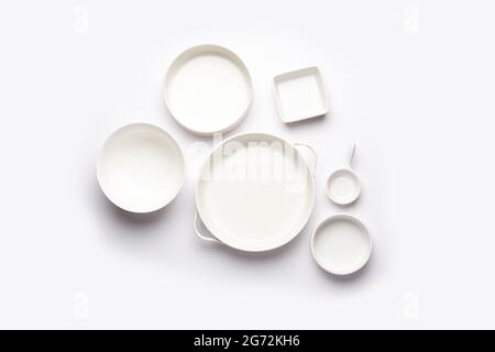 Collection of empty colorful ceramic bowls. Group of utensils captured from above, top view, flat lay against white background Stock Photo