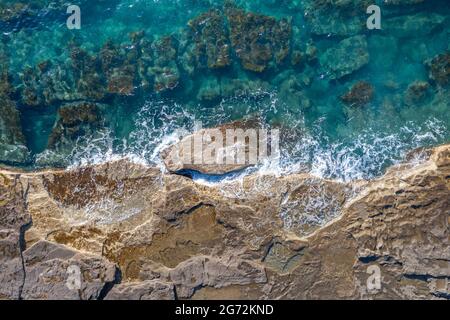 Sea waves breaking on rocky shore, aerial natural background Stock Photo