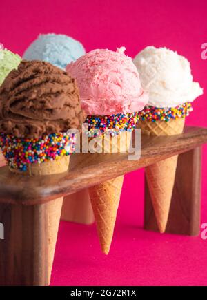 Six Different Flavors of Ice Cream in Sugar Cones on a Bright Pink Background Stock Photo
