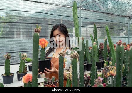 Asian young woman cheerful with the cactus in the greenhouse farm Stock Photo