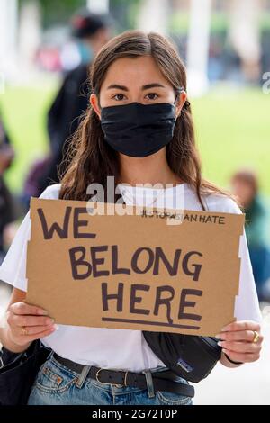 London, UK. 10th July, 2021. A protester holds a placard that says 'We belong here' during a Stop Asian Hate protest at Parliament Square in London.Anti-Asian violence and abuse has escalated since the COVID-19 pandemic first case was reported in the city of Wuhan, in Hubei province of China. (Photo by Dave Rushen/SOPA Images/Sipa USA) Credit: Sipa USA/Alamy Live News Stock Photo