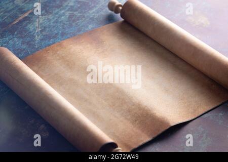 An Open Blank Scroll on a Blue Rustic Wooden Table Stock Photo