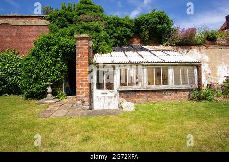 Old shabby garden green house Stock Photo