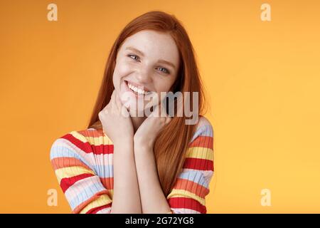 Silly enthusiastic attractive redhead blue-eyed girl tilting head touching neck flirty smiling enjoy perfect day feel happiness joy giggling Stock Photo