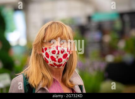 East Molesey, Surrey, UK. 8th July, 2021. Face masks and flowers in the Floral Marquee at the RHS Hampton Court Palace Garden Festival. Guests were required to provide a negative Covid-19 test or proof of their double Covid-19 jabs before being allowed entry to the festival. Credit: Maureen McLean/Alamy Stock Photo