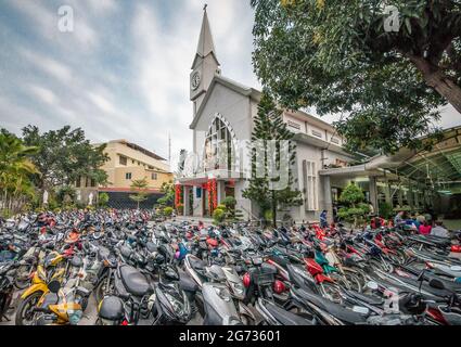 hundreds of motorcycles in front of a church in vietnam Stock Photo