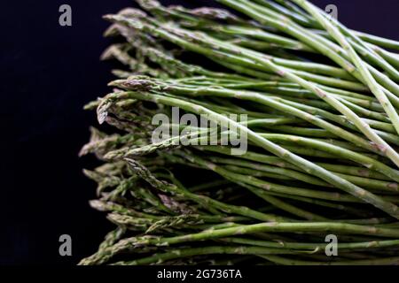 Green fresh asparagus on black slate stone background. Top view Stock Photo
