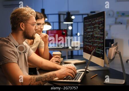 Young programmers working with computer in office at night Stock Photo