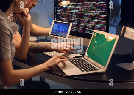 Young programmers working with laptop and tablet computer in office at night Stock Photo